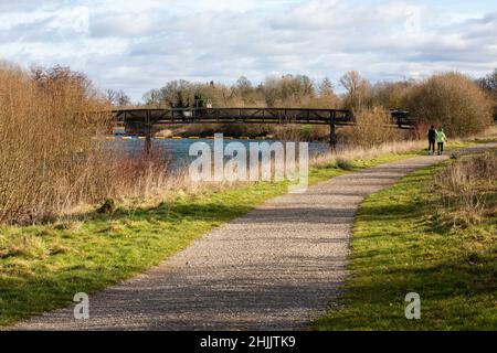 Eton Wick, UK. 29th January, 2022. Joggers approach a footbridge on the Jubilee River Way. The Jubilee River is a 11.6km hydraulic channel constructed between 1995-2006 to alleviate flooding to areas in and around Maidenhead, Windsor and Eton. Credit: Mark Kerrison/Alamy Live News Stock Photo