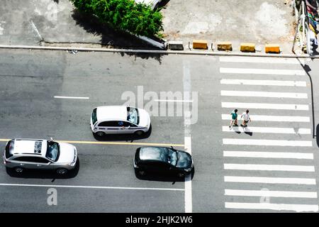 Aerial view of a black car stopped at a pedestrian crossing on a city ...