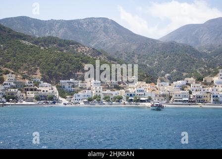 Diafani port,  Karpathos island - Greece - August 26 2014 : .Panoramic view of the charming town, with pine-clad dramatic hills as background.  Landsc Stock Photo