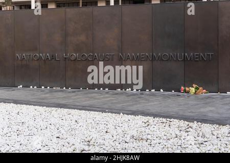 Amsterdam, Netherlands. 30 Jan 2022. White pebbles and a bouquet of flowers near the wall  the Dutch Holocoust Name Monument on Nationol Holocoust Memorial day. Credit: Steppeland/Alamy Live News. Stock Photo