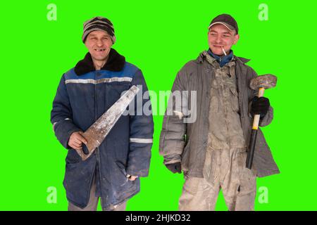 Two bad unskilled builder workers in bad dirty tattered uniform with bad tools. Concept of unskilled workers or crooks or poor quality workers Stock Photo