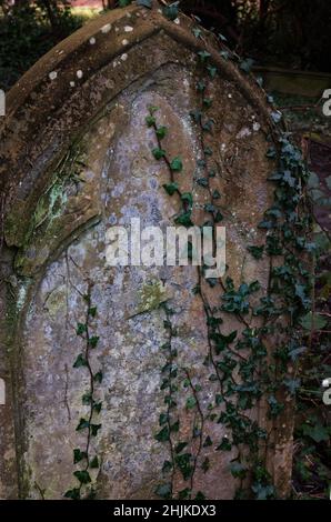 Ancient worn tombstone in Victorian cemetery Stock Photo