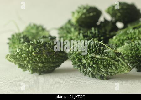 Bitter melon, also known as bitter gourd or pavakka or karela is a tropical vine that belongs to the gourd family with bitter taste. Shot on white bac Stock Photo