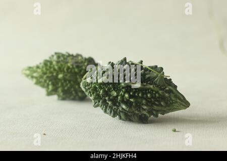 Bitter melon, also known as bitter gourd or pavakka or karela is a tropical vine that belongs to the gourd family with bitter taste. Shot on white bac Stock Photo