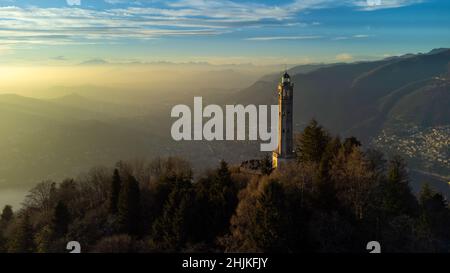 Aerial drone view of a lighthouse over Lake Como skyline with sunset light - Faro Voltiano (Volta Lighthouse) - Travel Destination, Brunate, Como, Lom Stock Photo