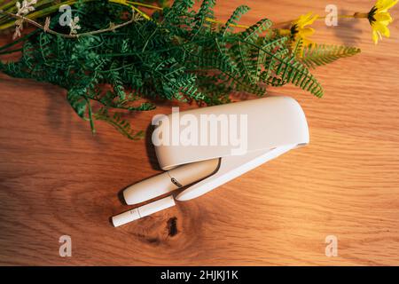 IQOS, a Tobacco heating system  by Philip Morris - tobacco product technologies - hybrid heets cigarette on a wooden background Stock Photo