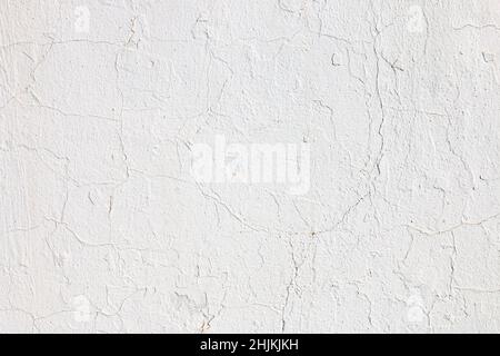 Wall plastered with cement and painted with white paint. The texture of cracks and imperfections can be seen. Stock Photo