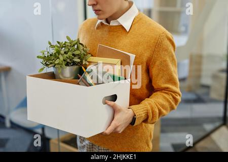 Cropped shot of young man carrying box of personal belongings starting new job in office, copy space Stock Photo