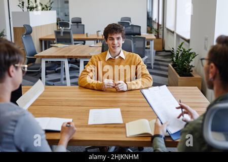 Portrait of smiling young man at job interview meeting with HR manager, copy space Stock Photo