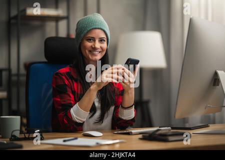 Happy female video editor works indoors in creative office studio, looking at camera. Stock Photo