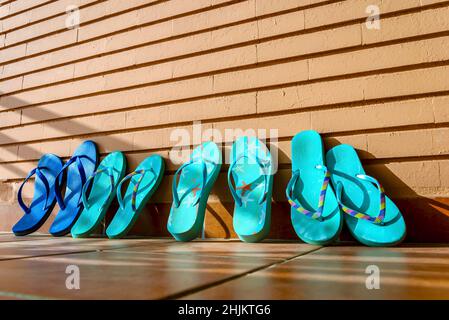 A family of flip flops rests and dries in the sun after a day on the beach Stock Photo