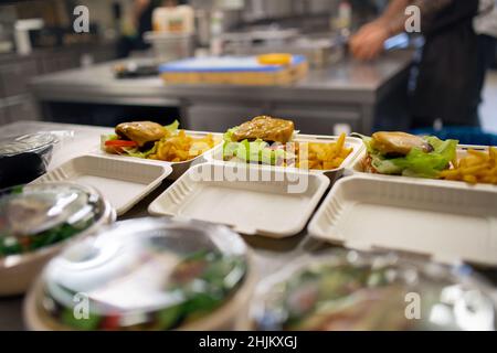Meals in containers prepared for take away in kitchen restaurant. Stock Photo