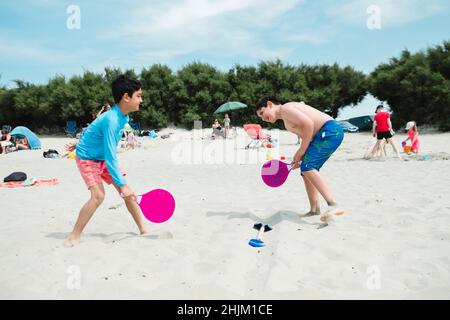 two boys playing on beach Stock Photo