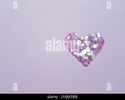 Heart made of sequins on a purple pape, top view, copy space Stock Photo