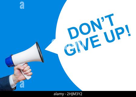 Man's Hand Holding Megaphone With Speech Bubble DON'T GIVE UP. Announcement And Advertising. Stock Photo