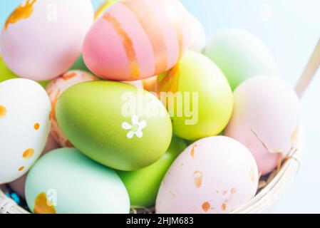 Easter basket filled with painted Easter eggs. Colorful painted Easter eggs in basket. Stock Photo