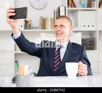 Young smiling cheerful businessman making selfie Stock Photo