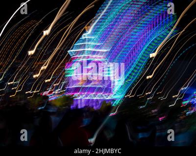 Christmas Tree full of Colored Lights out of Focus on a Dark Night Stock Photo