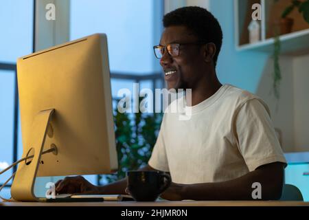 Successful software engineer coding on computer at home late at night enjoy overtime work on startup Stock Photo