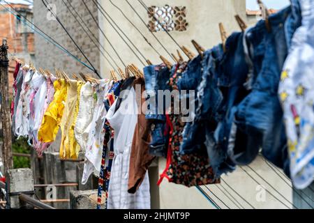 Different clothes hanging on a clothesline. Stock Photo