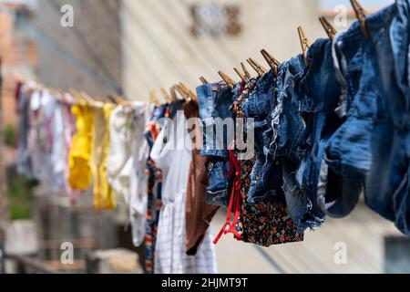 Different clothes hanging on a clothesline. Stock Photo