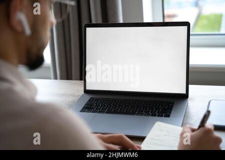 Young man working on laptop with blank copy space screen from home office Stock Photo
