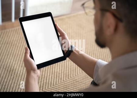 Man looking at blank mockup screen holding tablet digital device in hand Stock Photo
