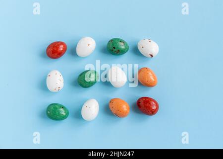 Easter minimal composition with multicolored eggs on the blue background. Easter concept. Flat lay. Stock Photo