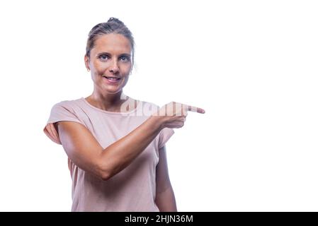 A smiling woman pointing with her finger looking at camera Stock Photo