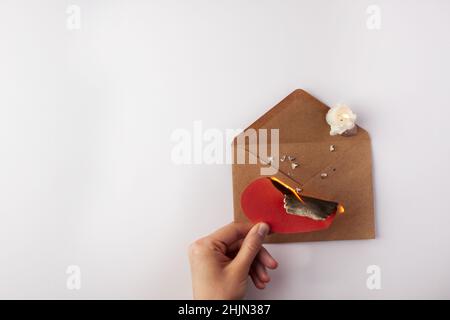 Valentine's Day. A valentine's heart burns over an envelope in a girl's hand. Top view. Copy space. Place for text. Stock Photo