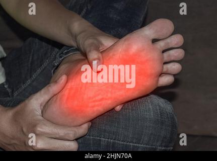 Tingling and burning sensation in foot of Asian young man with diabetes. Foot pain. Sensory neuropathy problems. Foot nerves problems. Plantar fasciit Stock Photo