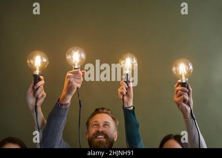 Employees hold lightbulbs develop business ideas Stock Photo