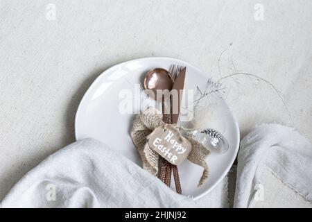 Festive Easter table setting with decor details on white table. Stock Photo