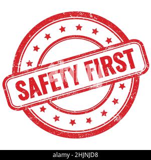 SAFETY FIRST text on red vintage grungy round rubber stamp. Stock Photo