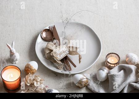 Festive Easter table setting with decor details on white table. Stock Photo