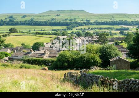 The view looking across the dales village of Askrigg in Wensleydale towards Addlebrough Hill Stock Photo
