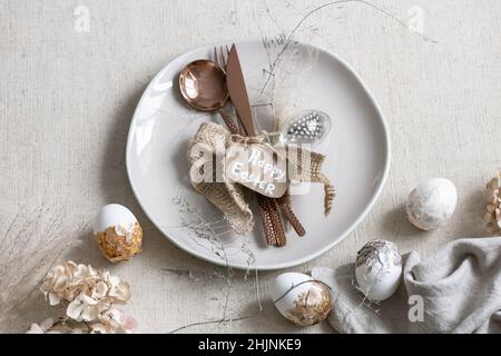 Festive Easter table setting with decor details on white table. Stock Photo