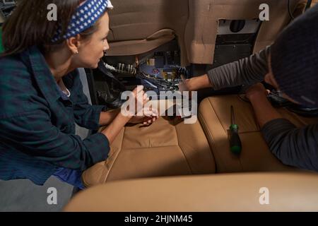 Two mechanics working together in salon of airplane while inspecting system Stock Photo