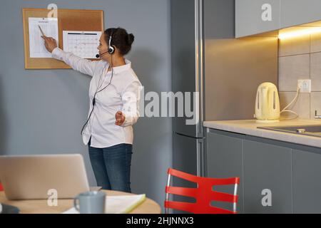 Distance education teacher showing paper to online students Stock Photo