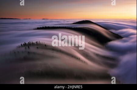 Beautiful sunset on the hill above clouds Stock Photo