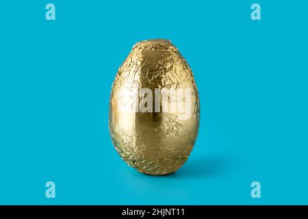 Golden Easter egg on blue background Stock Photo