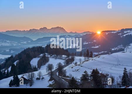 sunset in the snowy Bregenzer Wald area of Vorarlberg, Austria with spectacular view on Mount Saentis, Switzerland Stock Photo