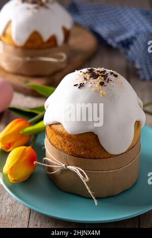 Traditional Easter cake, colorful eggs and tulips on wooden table. Stock Photo