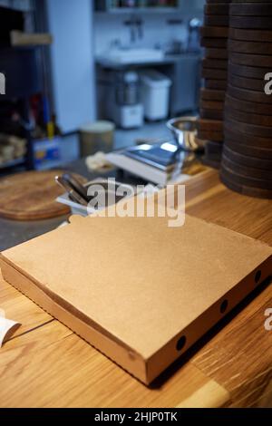 Pizza in a cardboard box against a dark background. Space for text. Pizza delivery Stock Photo
