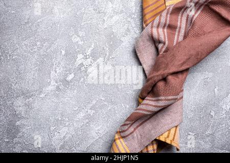 Top view of brown folded kitchen towel or serviette on grey concrete background Stock Photo