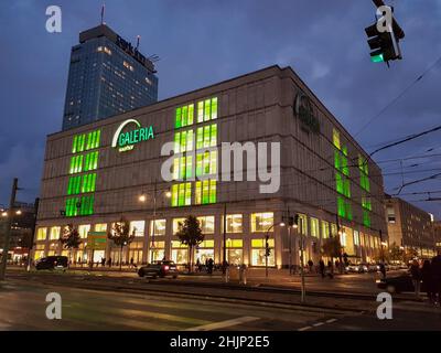 Berlin, Germany, October 2019: Galeria kaufhof Store. Evening, shop Windows and sign glow green. Behind the store building - Park Inn hotel. Stock Photo