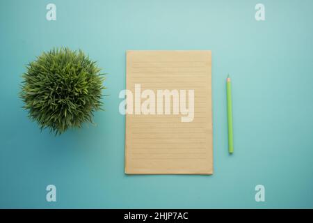 top view of blank paper and pencil on light green background  Stock Photo