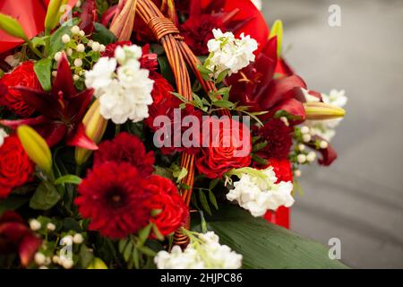 Flowers on memorial. Details of funeral decoration. Bouquet of flowers on grave. Mourning ceremony. Stock Photo