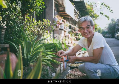asian senior man relaxing with smiling face at home garden Stock Photo
