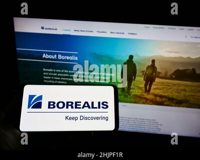 Person holding smartphone with logo of Austrian chemical company Borealis AG on screen in front of website. Focus on phone display. Stock Photo